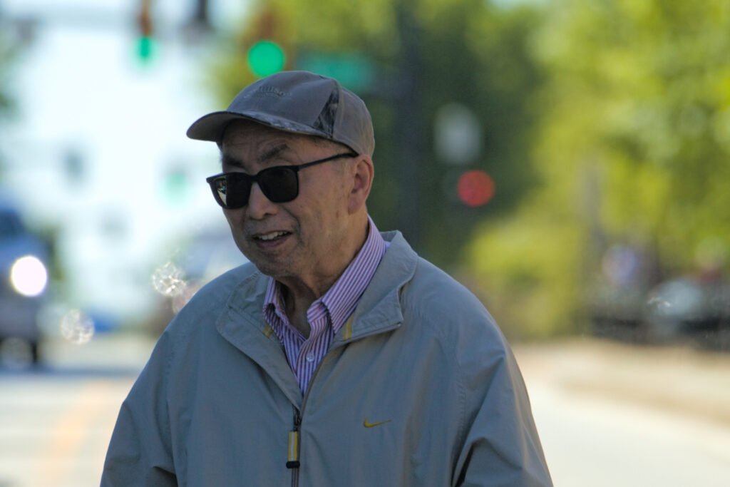 Old man smiles as he cross the street in the Village during Purdue's Grand Prix weekend