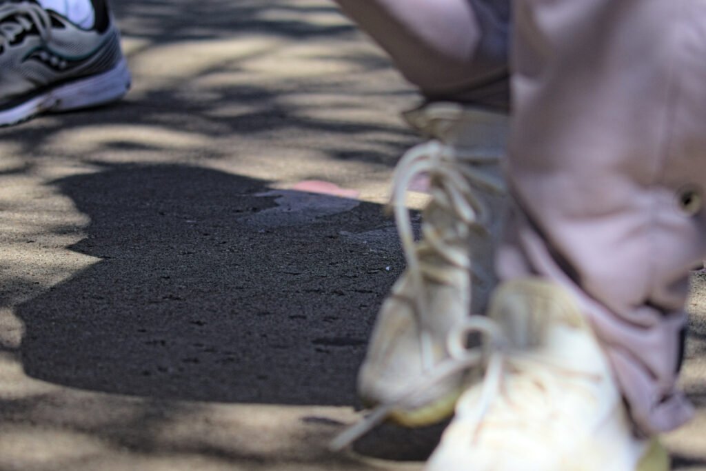 Ice cream spilled on the sidewalk and pedestrians walking through it during Purdue's Grand Prix weekend